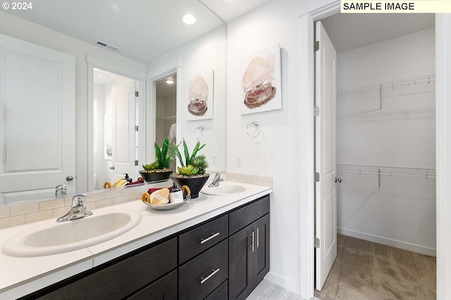 full bathroom featuring double vanity, a spacious closet, recessed lighting, and baseboards