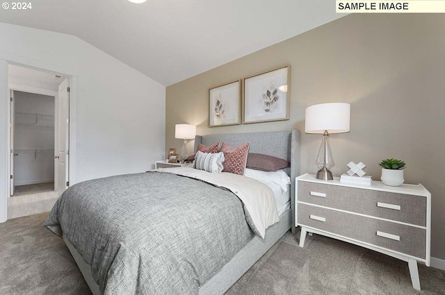 bedroom featuring carpet floors, lofted ceiling, a walk in closet, and baseboards