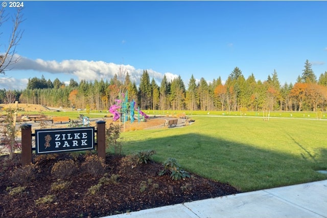 view of community with a lawn and a view of trees