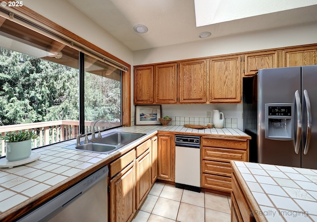 1929 SW Broadleaf Dr, Portland, OR 97219 - kitchen with stainless steel appliances, tile counters, a skylight, and light tile patterned flooring