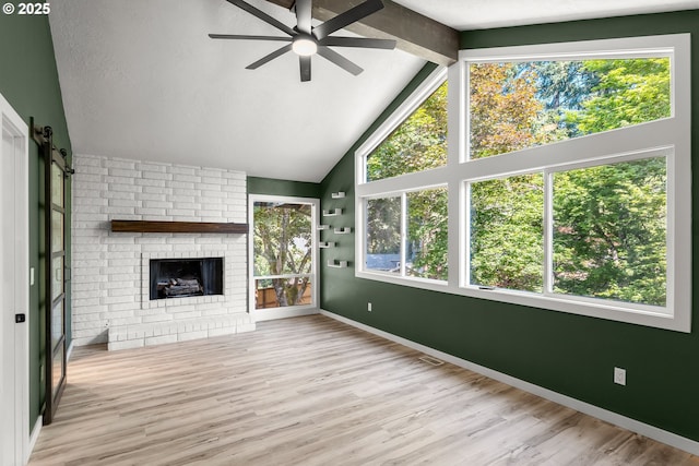unfurnished living room featuring ceiling fan, wood finished floors, baseboards, high vaulted ceiling, and beamed ceiling