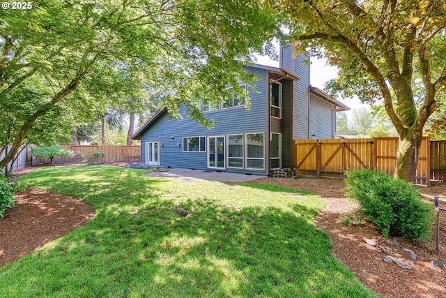 back of house with a fenced backyard, a yard, and a chimney