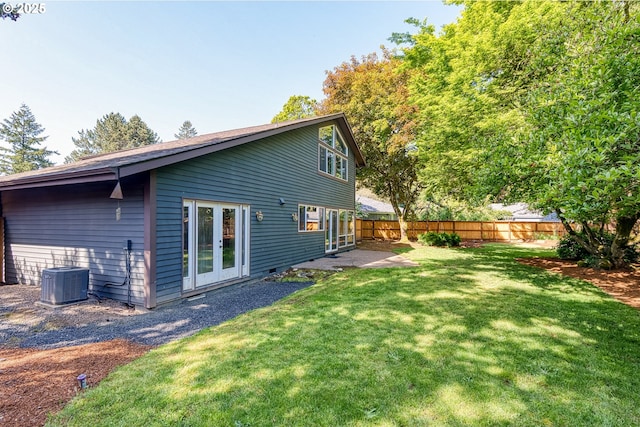 back of house with a lawn, central AC, french doors, and a fenced backyard