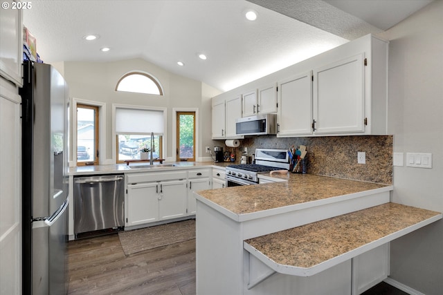 625 SE 7th Pl, Canby, OR 97013 - kitchen with stainless steel appliances, a sink, dark wood finished floors, a peninsula, and vaulted ceiling