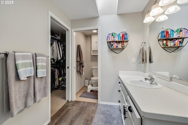 625 SE 7th Pl, Canby, OR 97013 - bathroom with wood finished floors, vanity, toilet, a spacious closet, and baseboards