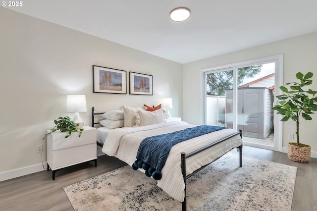 bedroom featuring wood-type flooring and access to exterior