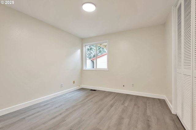 unfurnished bedroom with light hardwood / wood-style flooring and a closet