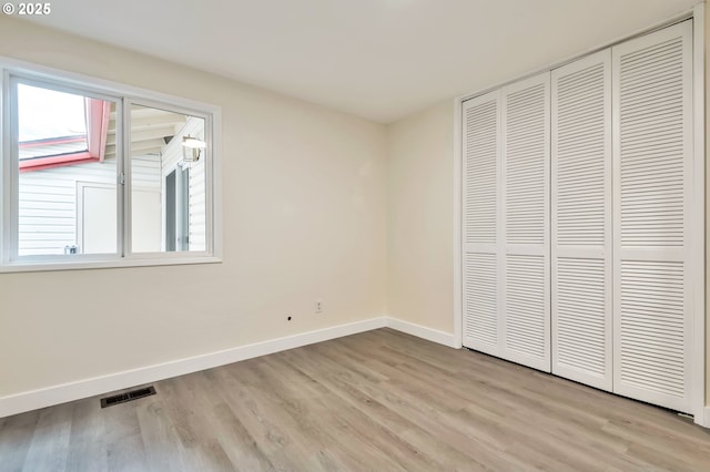 unfurnished bedroom with light hardwood / wood-style floors and a closet