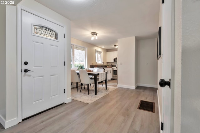 foyer featuring sink and light hardwood / wood-style floors