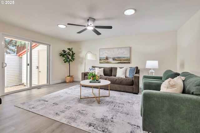 living room featuring ceiling fan and light hardwood / wood-style flooring