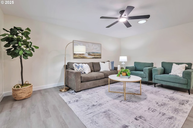 living room featuring light hardwood / wood-style flooring and ceiling fan