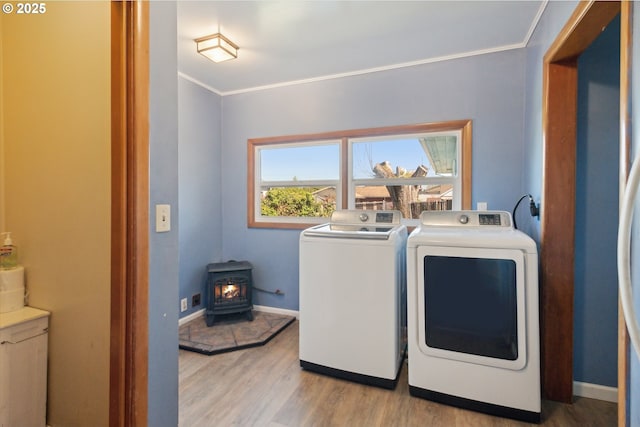 208 E 3rd St, Molalla, OR 97038 - laundry area featuring a wood stove, wood finished floors, washer and dryer, crown molding, and baseboards