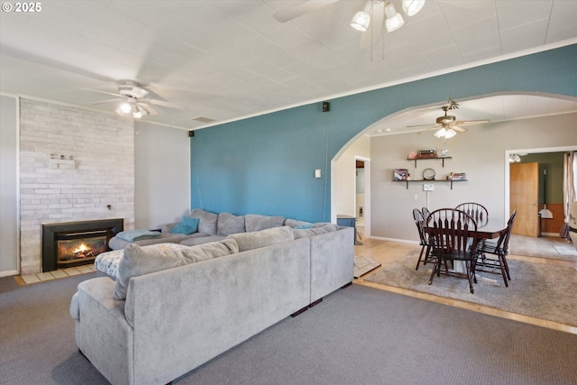 208 E 3rd St, Molalla, OR 97038 - living room featuring ceiling fan, arched walkways, a fireplace, crown molding, and carpet flooring