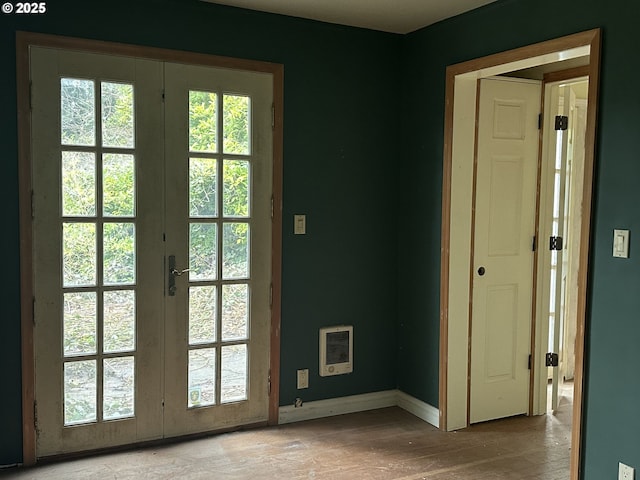 doorway featuring light wood-type flooring, french doors, and a healthy amount of sunlight