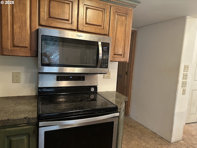 kitchen featuring stainless steel appliances, brown cabinetry, and tile countertops