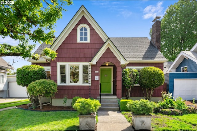 view of front of house featuring roof with shingles, a chimney, a front yard, and a garage