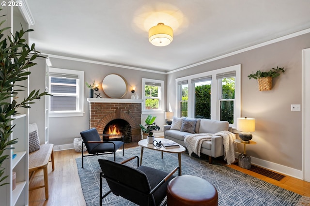 living area with a fireplace, baseboards, ornamental molding, and wood finished floors
