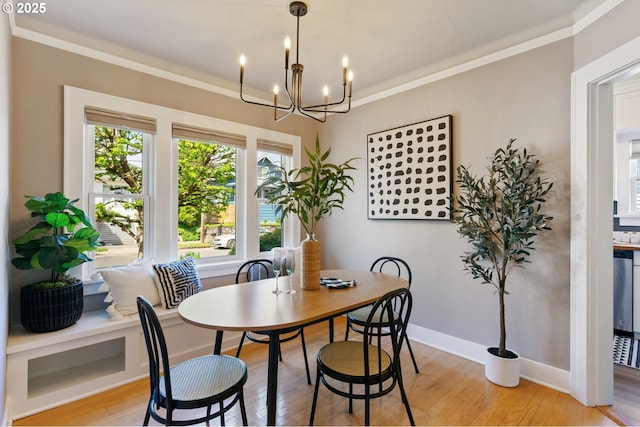 dining space featuring a chandelier, light wood-type flooring, crown molding, and baseboards