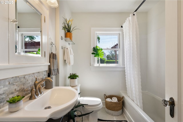 full bathroom with toilet, a sink, decorative backsplash, and shower / bath combo