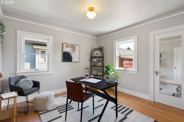 office area featuring healthy amount of natural light, ornamental molding, light wood-type flooring, and baseboards
