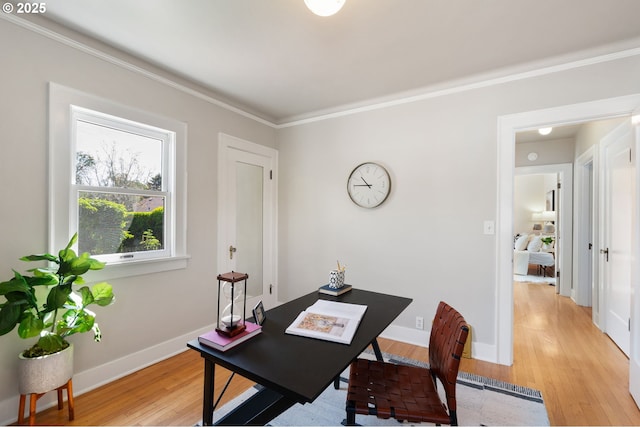 office area with light wood-style flooring, crown molding, and baseboards