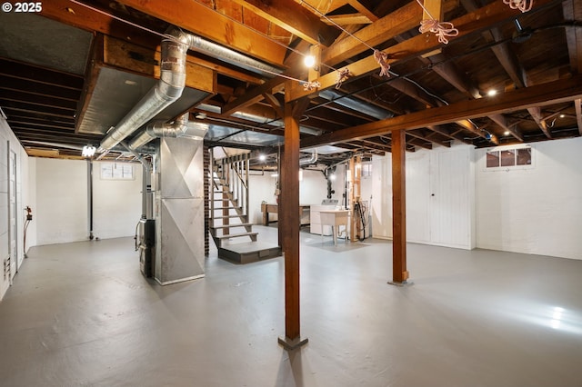 basement with stairway, heating unit, and washing machine and dryer