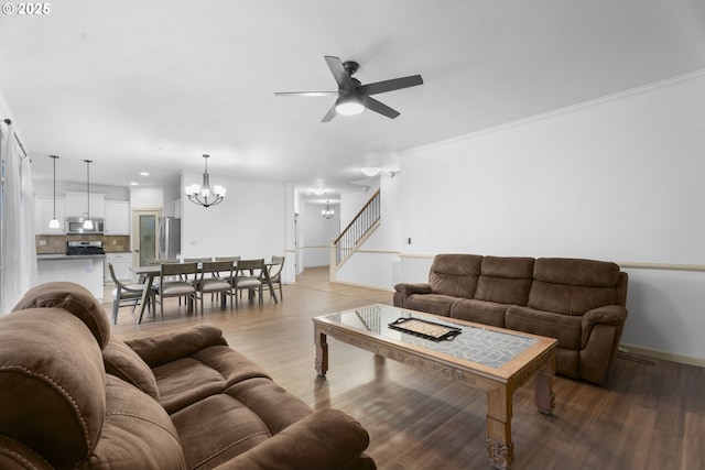 living room featuring ceiling fan with notable chandelier, hardwood / wood-style flooring, and ornamental molding