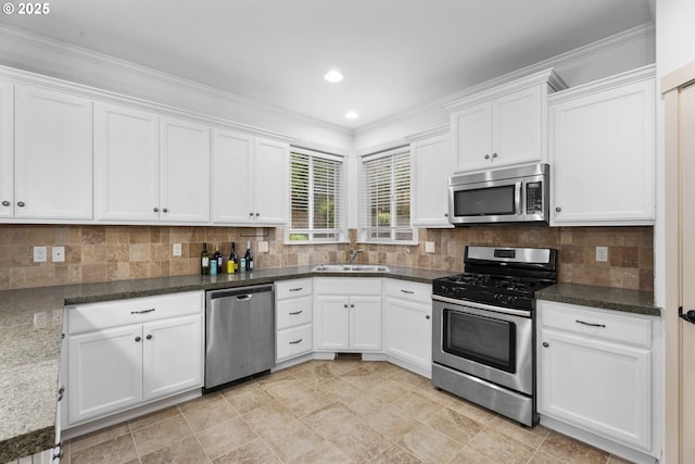 kitchen featuring dark stone countertops, white cabinetry, sink, and appliances with stainless steel finishes