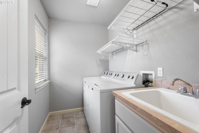 laundry room with washer and clothes dryer, sink, and a textured ceiling