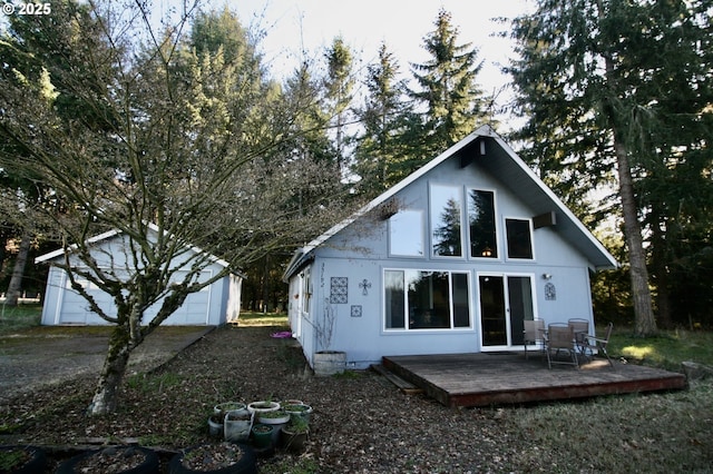 back of house with a wooden deck and an outbuilding