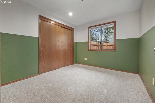 unfurnished bedroom with carpet floors, a closet, and a textured ceiling