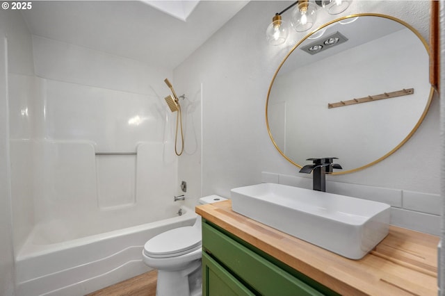 full bathroom featuring shower / tub combination, vanity, wood-type flooring, and toilet