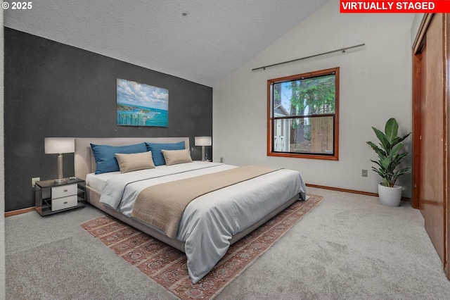 bedroom with lofted ceiling, carpet floors, and a textured ceiling