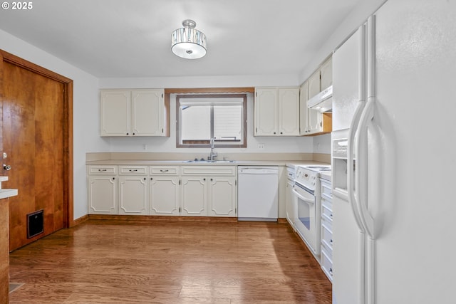 kitchen with sink, white cabinets, white appliances, and light hardwood / wood-style floors