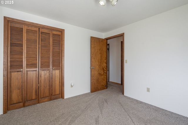 unfurnished bedroom featuring carpet flooring and a closet