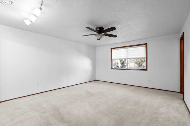 unfurnished room with ceiling fan, light carpet, and a textured ceiling