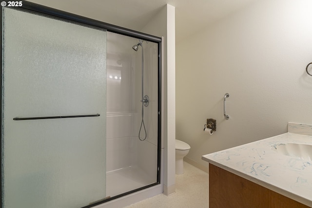 bathroom featuring a shower with door, vanity, and toilet