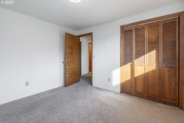 unfurnished bedroom with a closet and carpet flooring