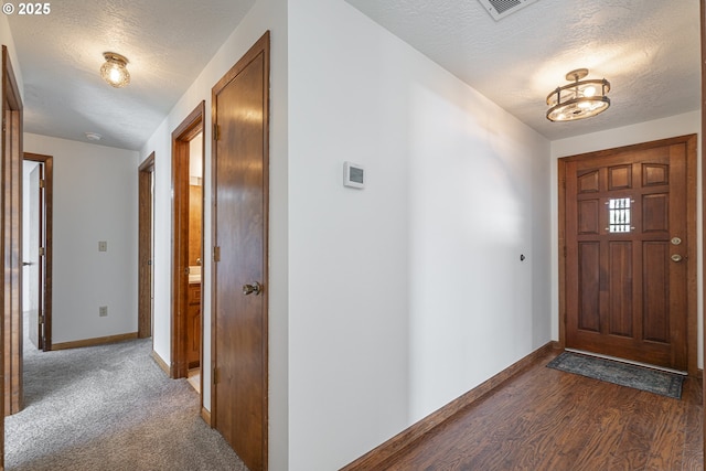 entrance foyer with dark hardwood / wood-style flooring and a textured ceiling