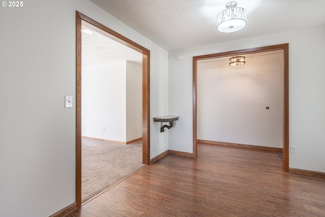 hallway with dark wood-type flooring and a textured ceiling