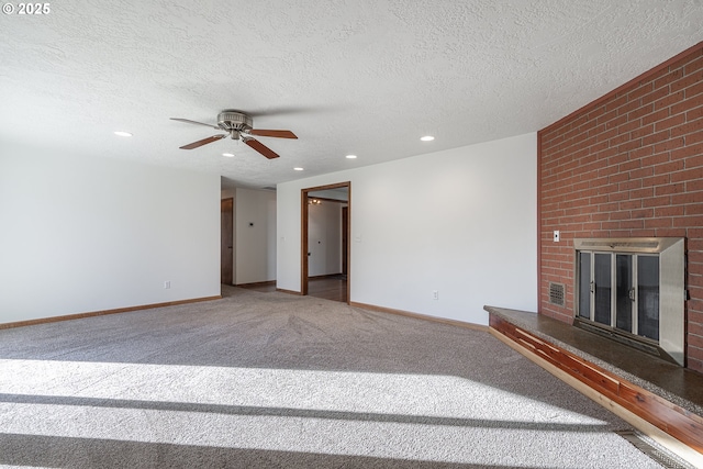 unfurnished living room featuring a fireplace, a textured ceiling, and carpet