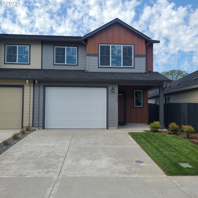 view of front of home featuring an attached garage, board and batten siding, fence, and concrete driveway