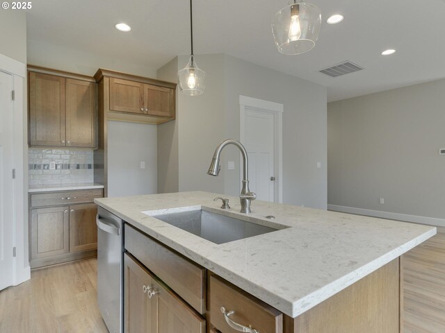 kitchen with visible vents, dishwasher, a sink, backsplash, and light wood-style flooring