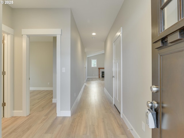 hallway with recessed lighting, light wood-style floors, and baseboards