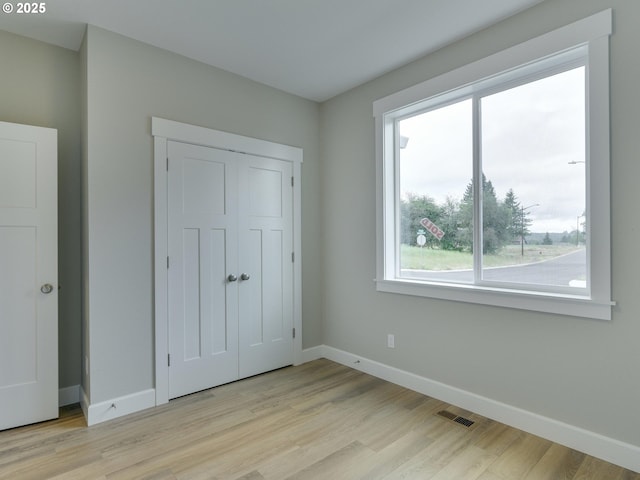 unfurnished bedroom featuring a closet and light hardwood / wood-style flooring