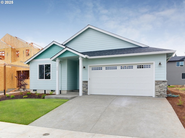 ranch-style home featuring a shingled roof, stone siding, a garage, concrete driveway, and a front lawn