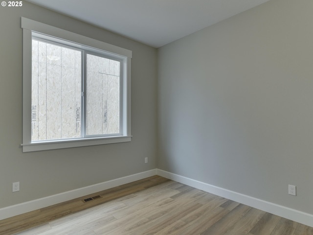 spare room featuring light hardwood / wood-style floors and a wealth of natural light