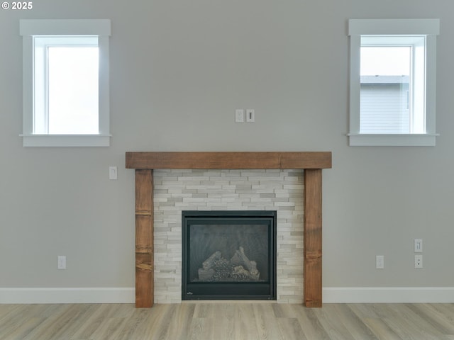 room details featuring wood finished floors, a fireplace, and baseboards