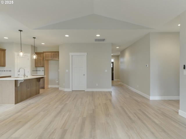 unfurnished living room featuring baseboards, vaulted ceiling, recessed lighting, visible vents, and light wood finished floors