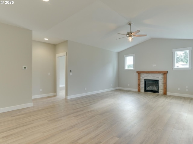 unfurnished living room with a tile fireplace, ceiling fan, light hardwood / wood-style flooring, and lofted ceiling